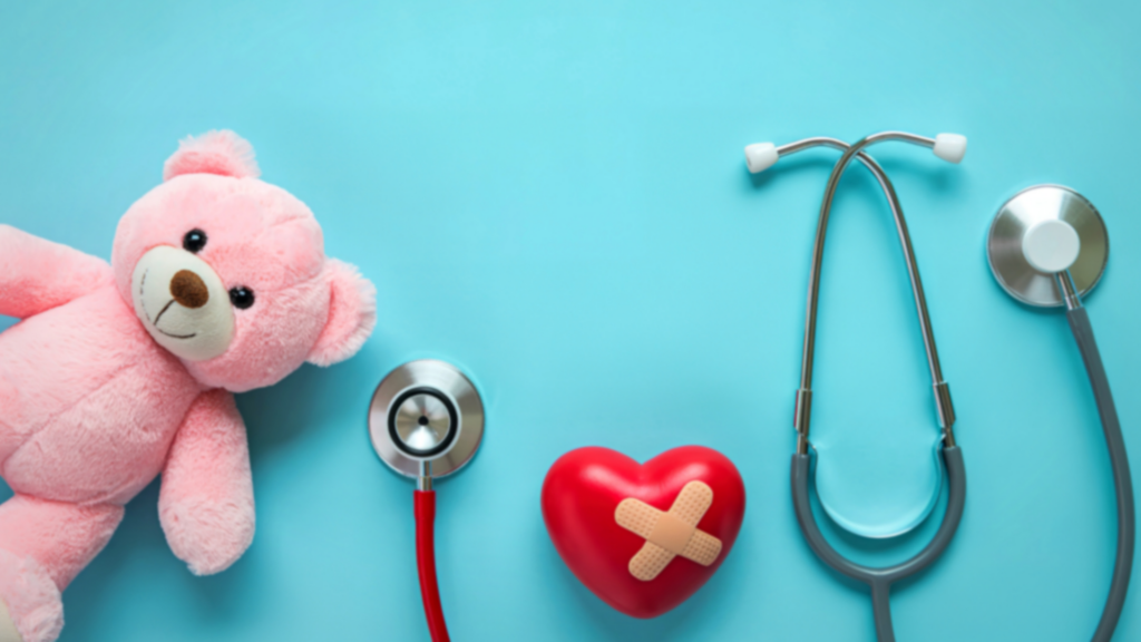 A friendly dentist showing a young child how to use a bamboo toothbrush on a colorful tooth model, both laughing in a bright, play-inspired treatment room.