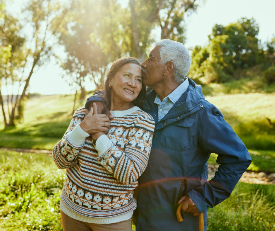 A professional, soft-focus shot of a patient smiling broadly in natural outdoor lighting, highlighting the seamless, light-reflecting quality of minimally invasive dental restorations.