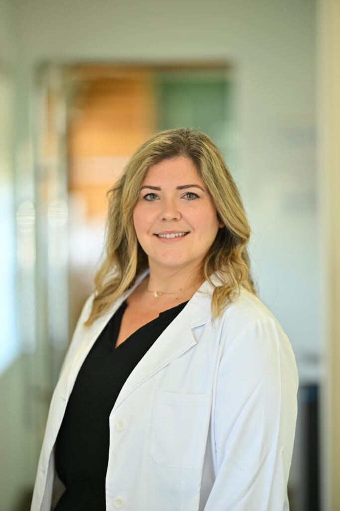 Professional headshot of Dr. David Li, smiling warmly in a white lab coat at Wellbeing Dentistry.