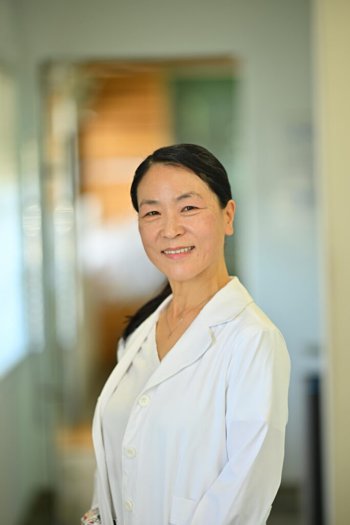 A professional portrait of Dr. Christina Pak, the lead dentist at Wellbeing Dentistry in Santa Clara, CA, welcoming patients to her holistic practice.