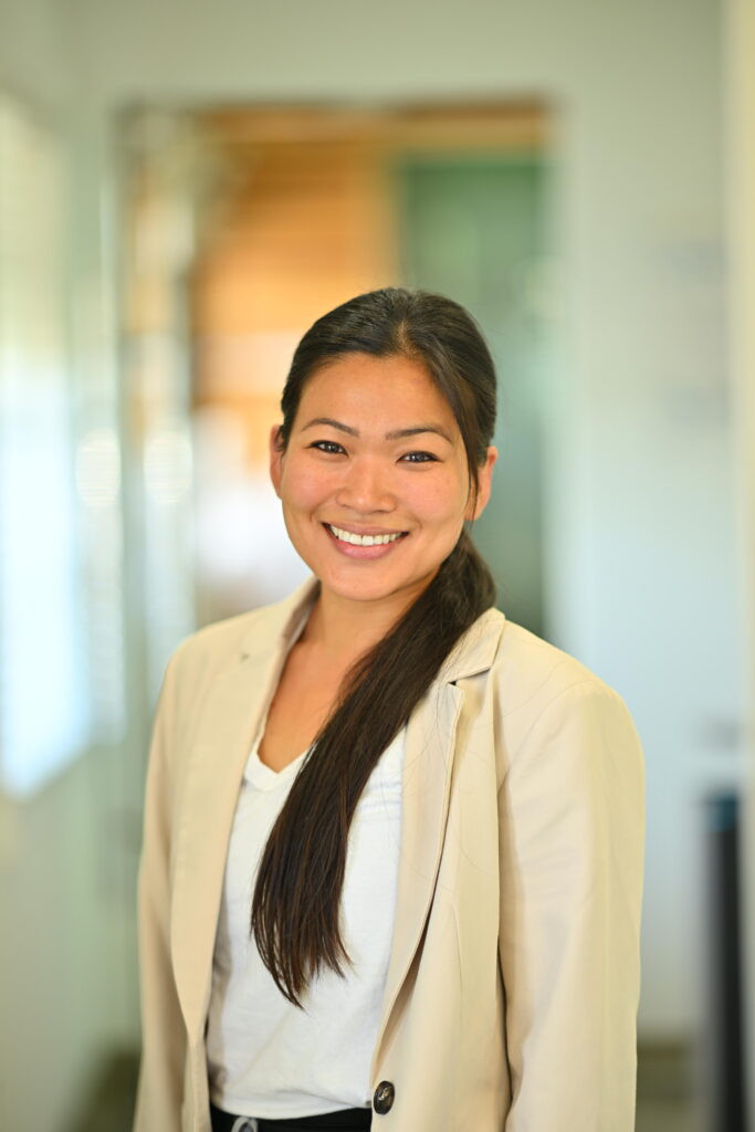 Professional headshot of Darlene Keo, smiling warmly in a beige blazer at Wellbeing Dentistry.
