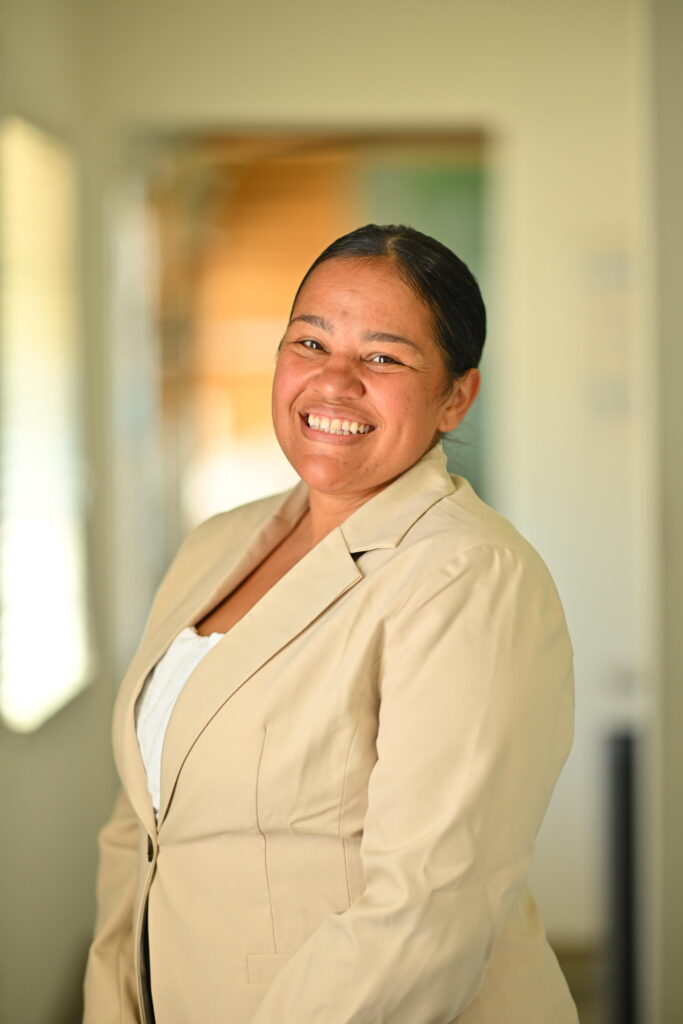 Professional headshot of Jennifer Johnson, smiling brightly in a beige blazer at Wellbeing Dentistry.
