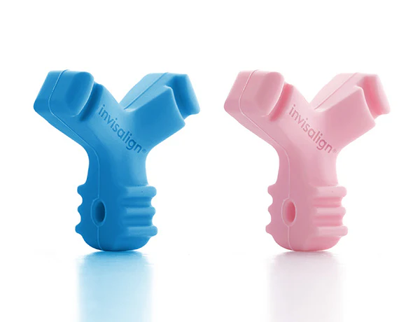 Two colorful Munchies (aligner chewies), one blue and one pink, used to help seat Invisalign or other clear aligners properly.